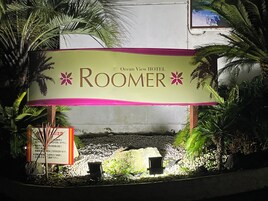 Señal para el RooMer del Hotel Ocean View, con un jardín tropical de fondo.