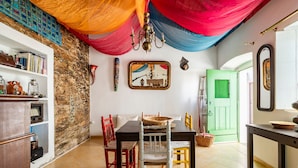 A dining area with a table, chairs, and a green door in the background.