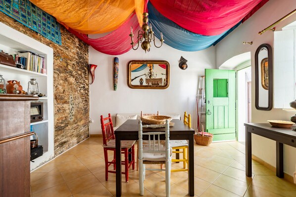 A dining area with a table, chairs, and a green door in the background.