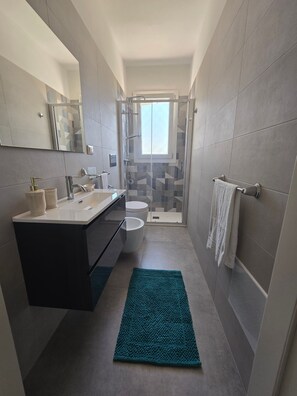 Et stilfuldt badeværelse med bruser, toilet og håndvask.