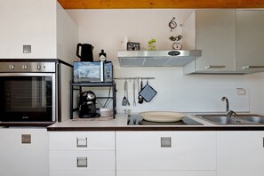A kitchen with a built-in oven, a coffee machine, a kettle, and a microwave. - Villa Monti with Private Pool, Wi-Fi, and Air Conditioning (Francavilla Fontana)