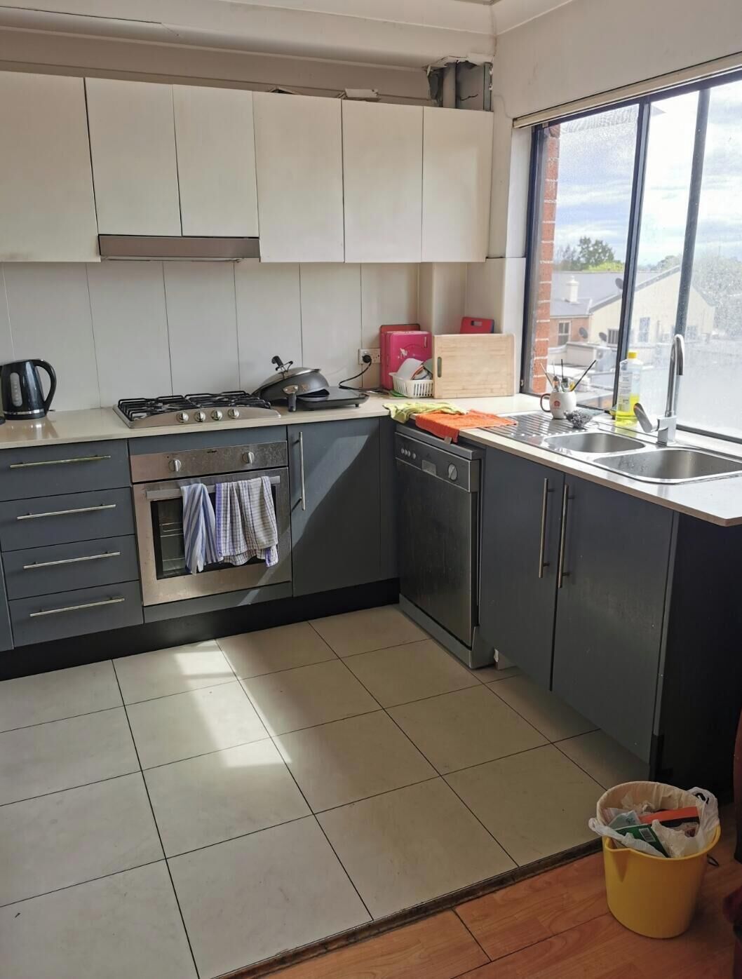 A kitchen with a gas stove, oven, dishwasher, and a window with a view.