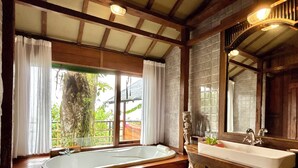 A bathroom with a freestanding bathtub, a sink, and a large mirror.