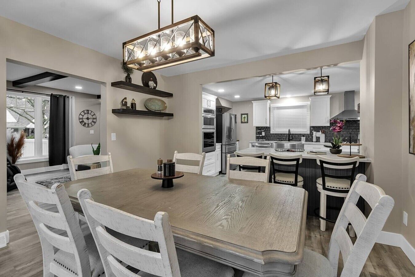 A modern kitchen with white cabinets, a central island, and pendant lighting.