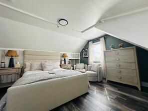 A bedroom with a bed, a dresser, a chair, and a nightstand.