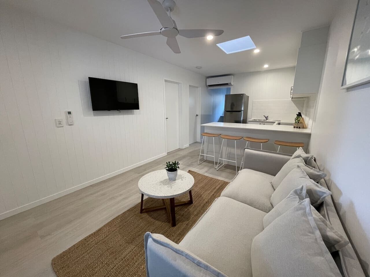A modern living room with a sofa, a coffee table, and a TV.