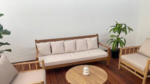 A wooden deck with a sofa, two chairs, and a round table. - Killara Apt 3 - Noosa Heads Holiday Apartment (Noosa Heads)