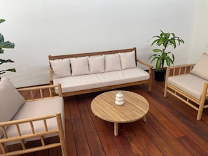 A wooden deck with a sofa, two chairs, and a round table. - Killara Apt 3 - Noosa Heads Holiday Apartment (Noosa Heads)
