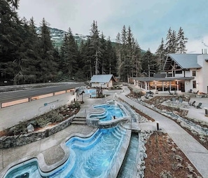 Un complexe hôtelier doté d’une piscine sinueuse, d’un chalet et offrant une vue imprenable sur les montagnes.