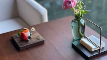 Una mesa de comedor con un florero y un pequeño soporte de metal.