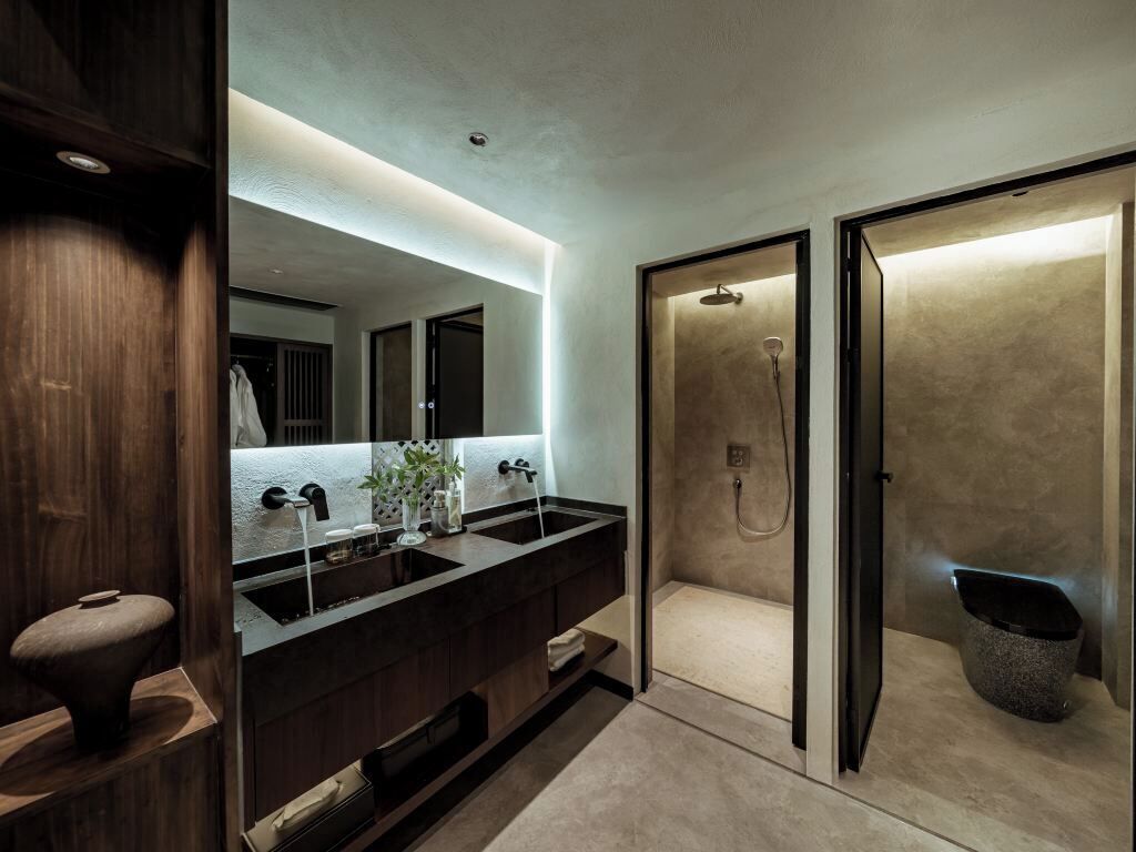 Un baño moderno con lavamanos doble, un espejo grande y una ducha a ras de suelo.