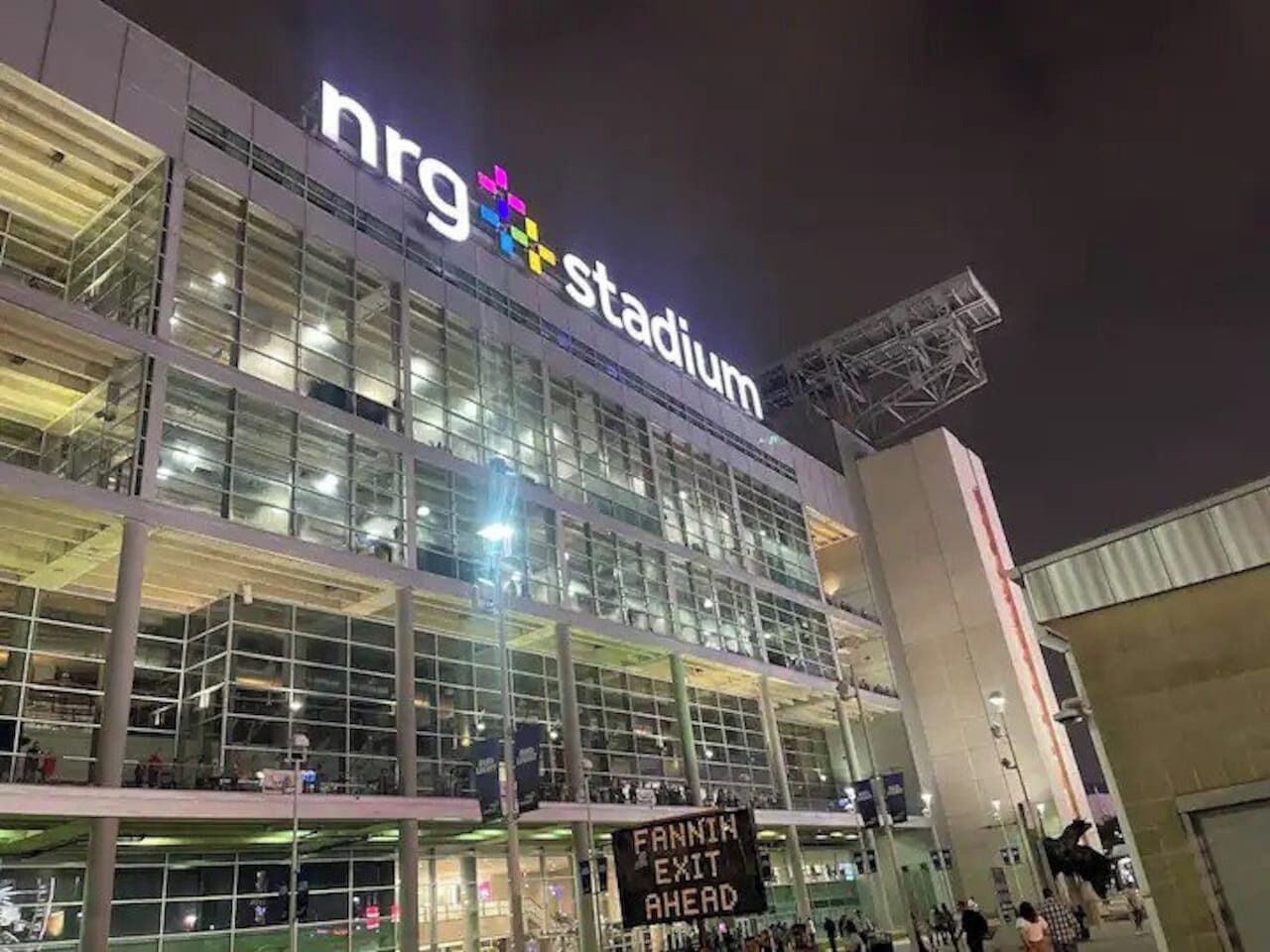 A modern stadium with a large glass facade and a prominent 'nrg stadium' sign.