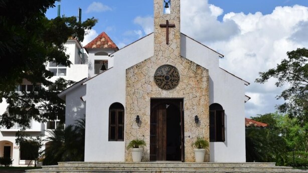 A white church with a stone facade, a bell tower, and a circular window. - Unknown Accommodation by Interhome (Bayahibe)