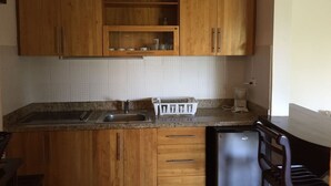 A kitchen with wooden cabinets, a granite countertop, a dishwasher, and a coffee maker. - Unknown Accommodation by Interhome (Bayahibe)