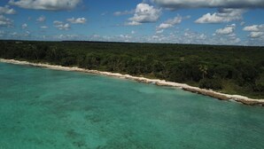 A coastal landscape with clear turquoise waters, a sandy beach, and dense green vegetation. - Unknown Accommodation by Interhome (Bayahibe)