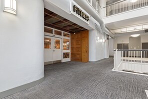 A fitness center with a sign, a wooden door, and a white railing. - New Downtown Indy-Skywalk Access -Sleeps 7 (Indianapolis)