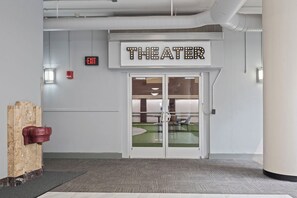 Ein Theater Eingang mit einem Schild, einem Ausgangsschild und einem Feuerlöscher.
