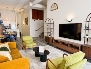 A living room with a sofa, armchairs, a coffee table, a TV, and a staircase. - New Downtown Indy-Skywalk Access -Sleeps 7 (Indianapolis)
