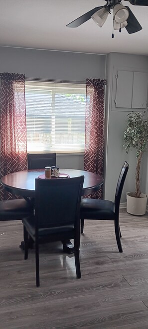 A dining area with a round table, chairs, and a ceiling fan. - Your Windsor Home Away from Home | 3BR One-Storey (Windsor)
