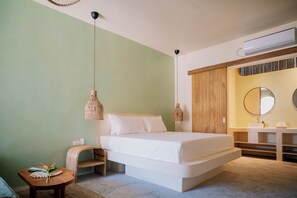 Un dormitorio con cama, mesita de noche y una pequeña mesa redonda con un objeto decorativo.