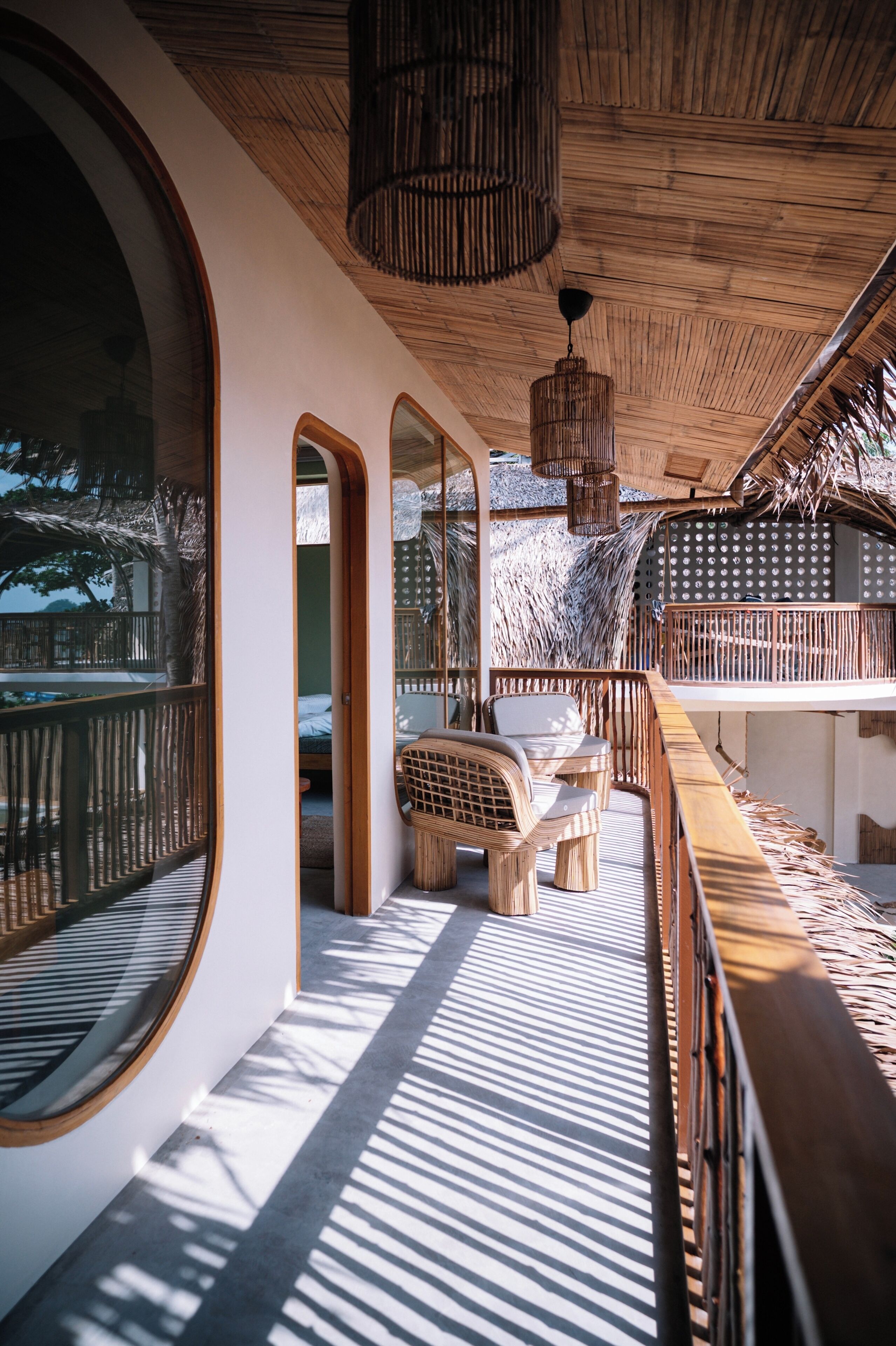 A room with a large circular window, a wooden ceiling, and a view of the outdoors.