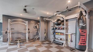 Een sportschool met een reksysteem voor squats, kettlebells en een bokszak.