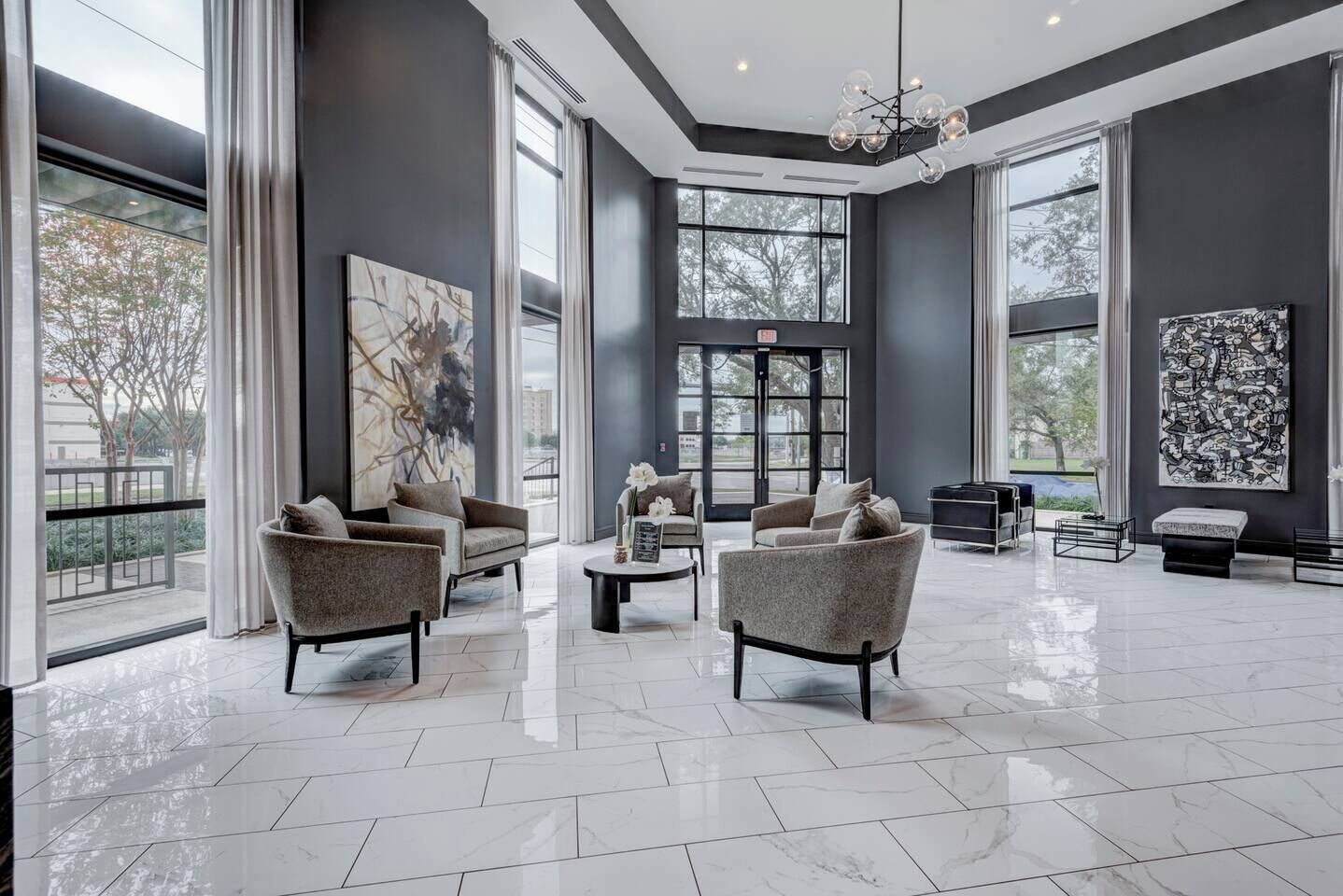 A spacious lobby with modern furniture, large windows, and artwork.