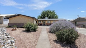 A residential building with a paved driveway, a small garden with shrubs, and a clear sky. - Shady Backyard Retreat  4BR Farmington  Sleeps 10 (Farmington)
