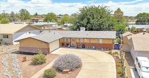 Edifício residencial com garagem, entrada por automóvel e jardim ajardinado.