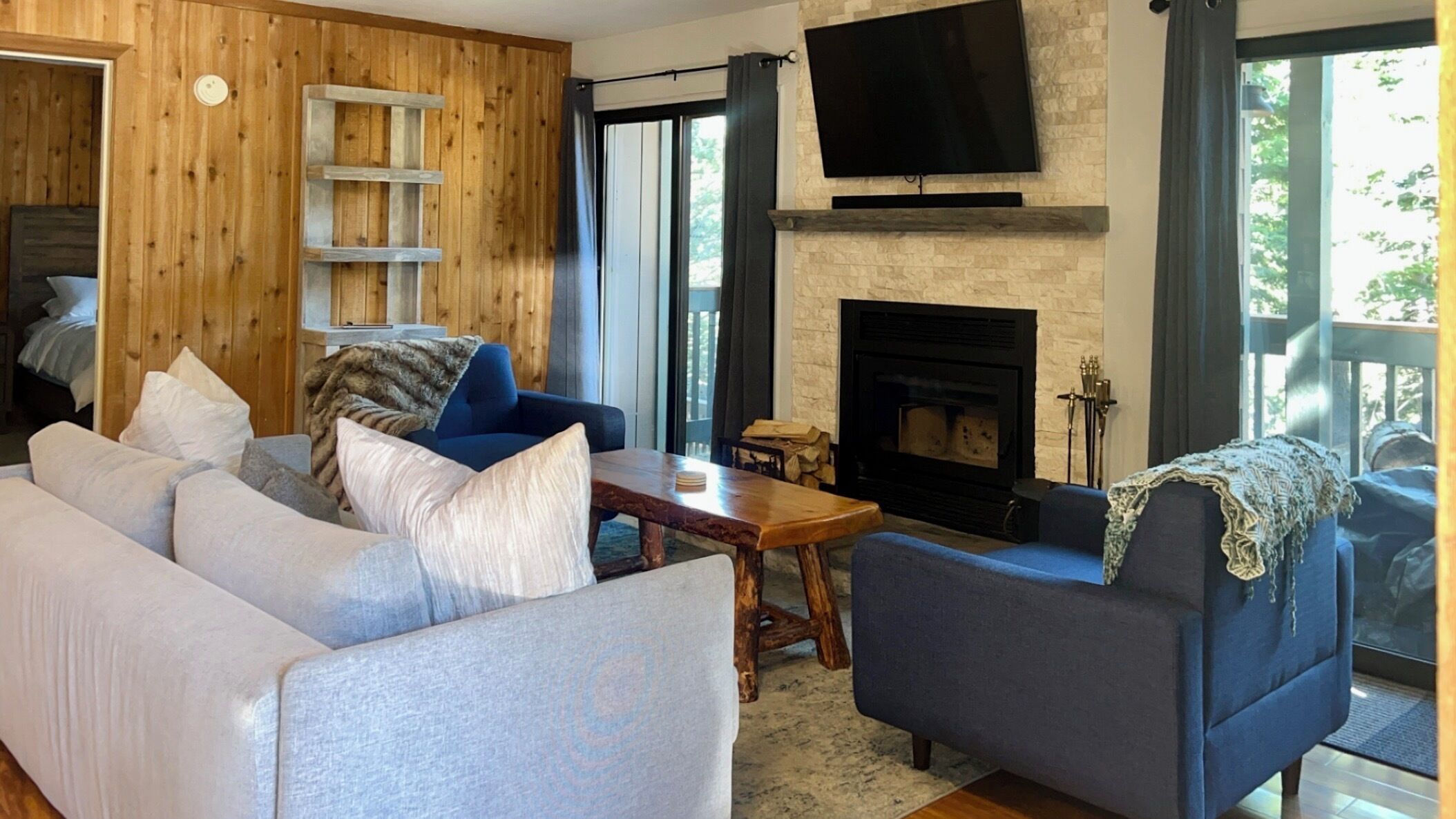 A living room with a sofa, armchair, and a fireplace.