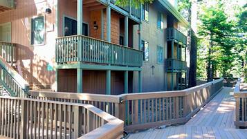 A multi-story building with balconies and a wooden deck.