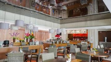 A multi-level restaurant with dining tables and chairs, a bar area, and a decorative ceiling.