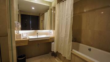 A bathroom with a bathtub, a sink, a mirror, and a shower curtain.