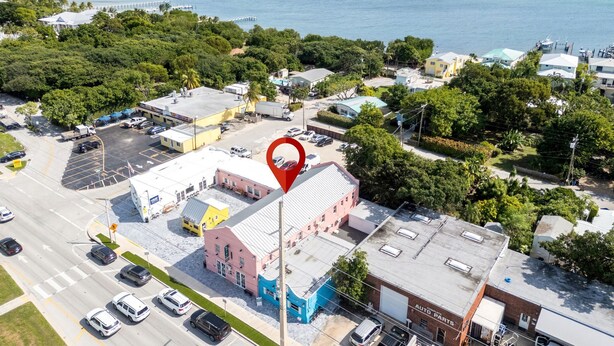 An aerial view of a coastal town with a prominent pink building, a marina, and a clear view of the ocean. - Cozy 2-bedroom apartment with AC and kitchen, Tavernier (Tavernier)