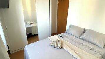 Una camera da letto con un letto, una ventola a soffitto e un armadio.