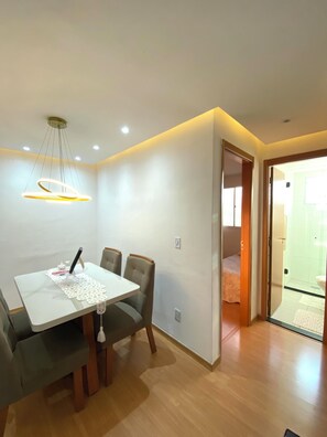 A dining area with a table, chairs, and a pendant light fixture. - 2 bedroom apartment • With 1 vacancy • Near Galeão Airport (Duque de Caxias)