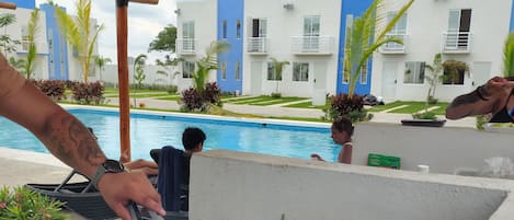A poolside barbecue grill with various meats and vegetables being cooked.