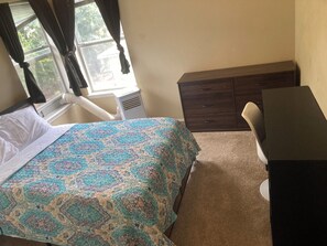 A bedroom with a bed, a dresser, a desk, and a window with curtains. - 4BR Denton Home Near UNT & TWU--Perfect for Work Trips & Families (Texarkana)