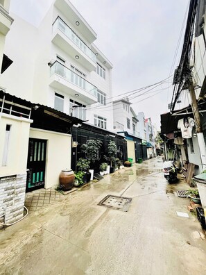 A narrow alleyway with buildings on either side, some with balconies and others with ground-level entrances. - 5 Beds for 10ppl l 3 Bedrooms l Near Thao Dien (Thành phố Hồ Chí Minh)