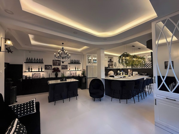 A modern kitchen with a central island, bar seating, and a dining area with chairs. - 5 Beds for 10ppl l 3 Bedrooms l Near Thao Dien (Thành phố Hồ Chí Minh)