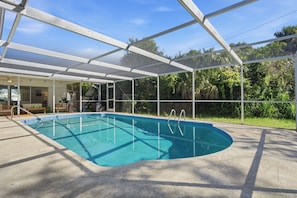 Ein überdachter Pool mit freiem Blick auf die umliegende Grünfläche.