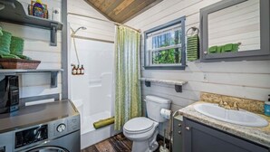 A compact bathroom with a toilet, sink, and a washing machine.