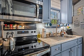 Une cuisine moderne équipée d’appareils électroménagers en acier inoxydable, d’une bouilloire et de divers ustensiles de cuisine.