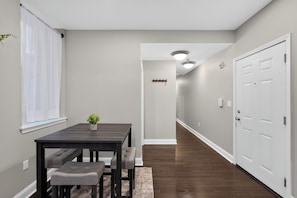 A hallway with a dining table, benches, a potted plant, and a door at the end. - Serene 2-bedroom apartment in Center City Philadelphia (Philadelphia)