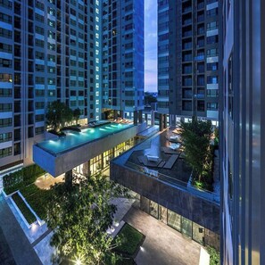 A high-rise building with multiple balconies and a rooftop swimming pool. - Central Pattaya Sunset Bliss With Infinity Pool (Pattaya)