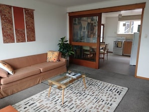A living room with a sofa, coffee table, and a patterned rug.