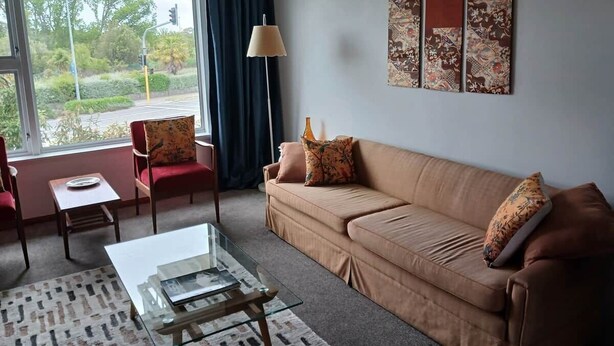 Ein Wohnzimmer mit Sofa, Sessel, Couchtisch und einer Lampe.