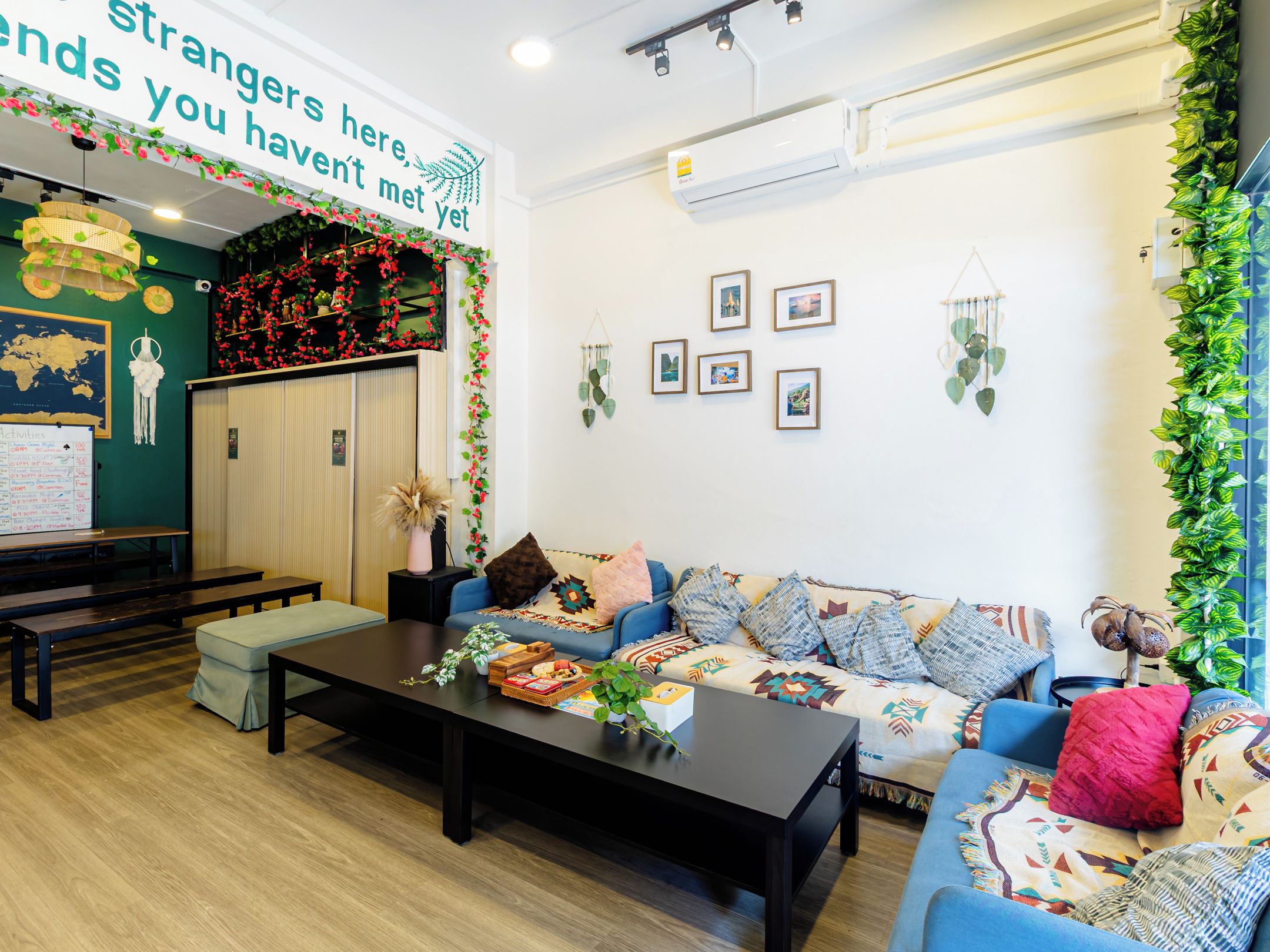 Un espace salon confortable avec un canapé, une table basse et un tableau d’affichage où sont indiquées les activités proposées.