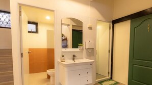 Une salle de bain avec un lavabo blanc, un miroir et un mur recouvert de panneaux en bois.