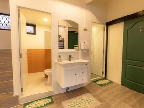 Ein Badezimmer mit einem weißen Waschbecken, einem Spiegel und einer Wandpaneelaus Holz.